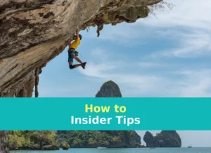 man climbing cliff beside beach