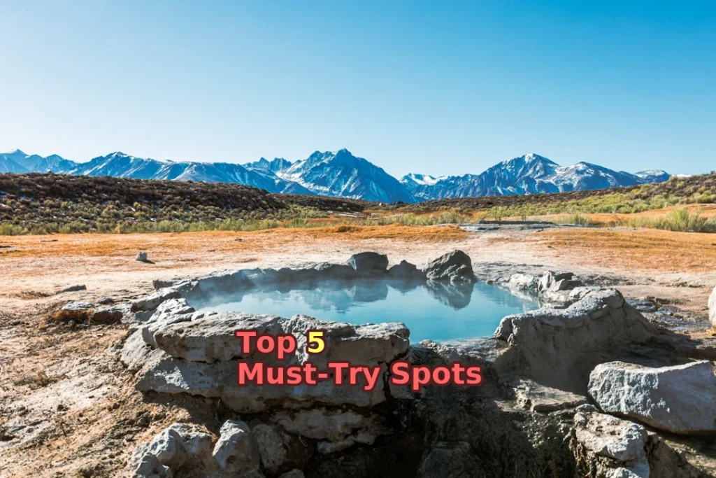 brown field near mountain under blue sky during daytime