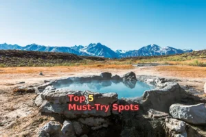 brown field near mountain under blue sky during daytime