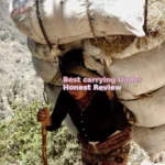 woman carrying sack of hay on back while holding stick