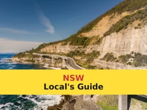 gray concrete bridge on brown rocky mountain beside blue sea under blue sky during daytime