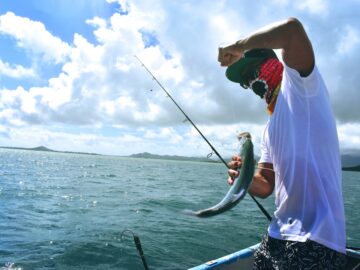 man in white t-shirt holding a fish