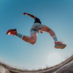 man leaping while trail running