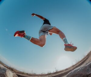 man leaping while trail running
